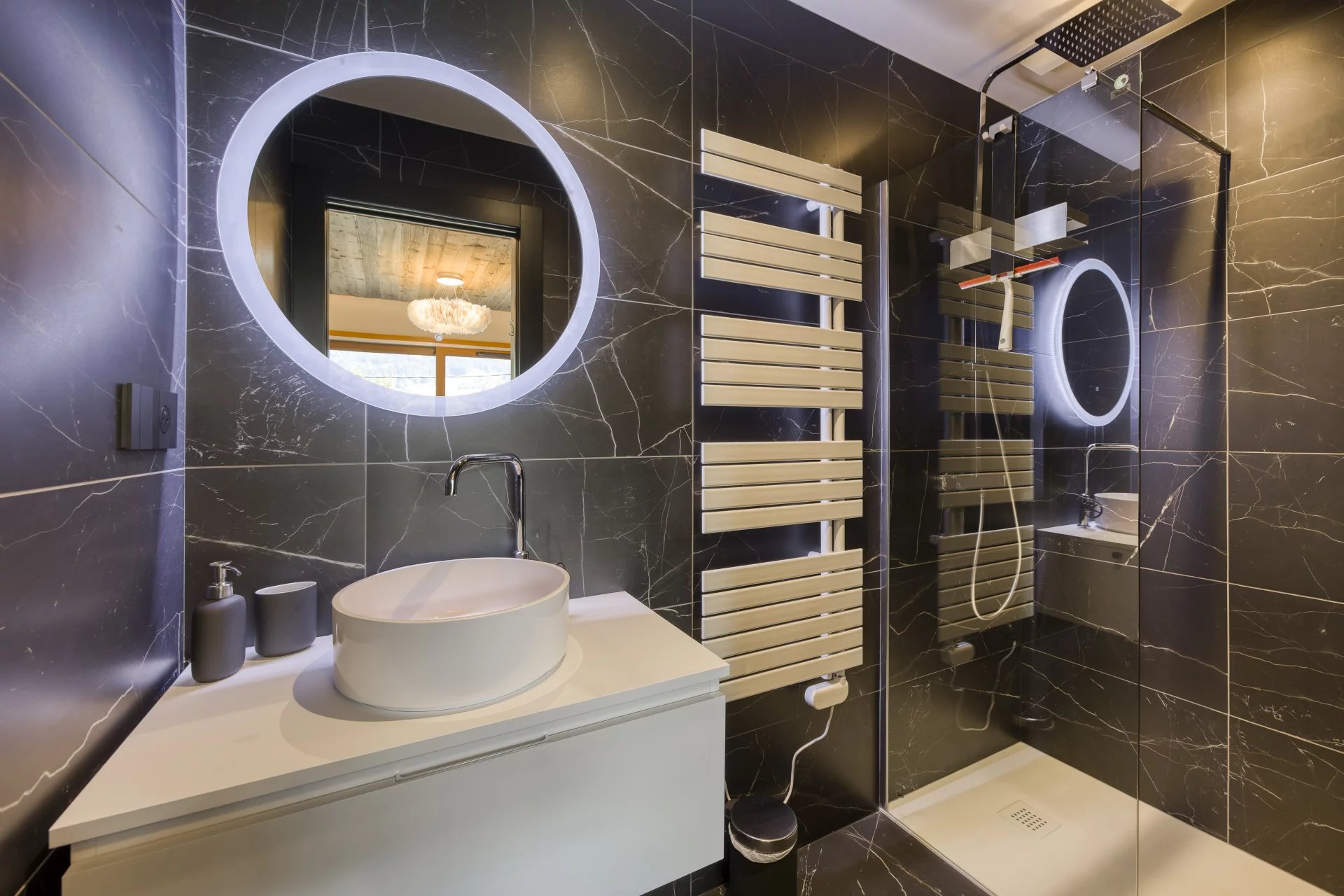 Salle de bain, marbre noir, miroir rond rétroéclairé